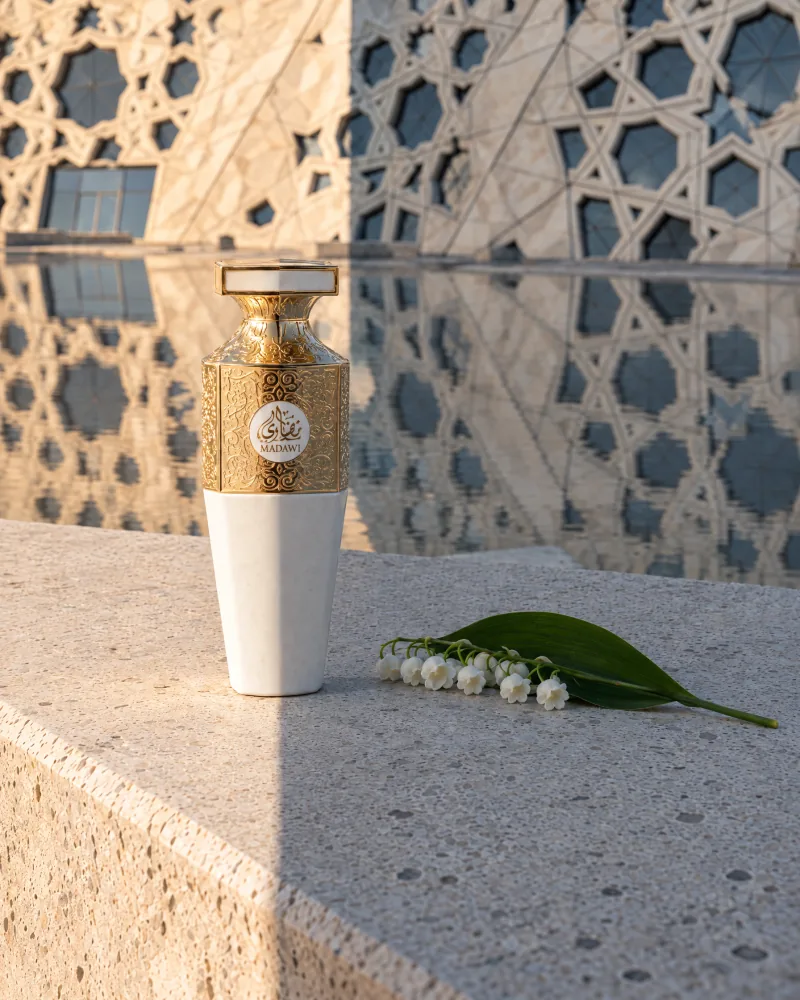 Madawi White on a stone ledge before a cultural centre facade, beside a sprig of lily of the valley