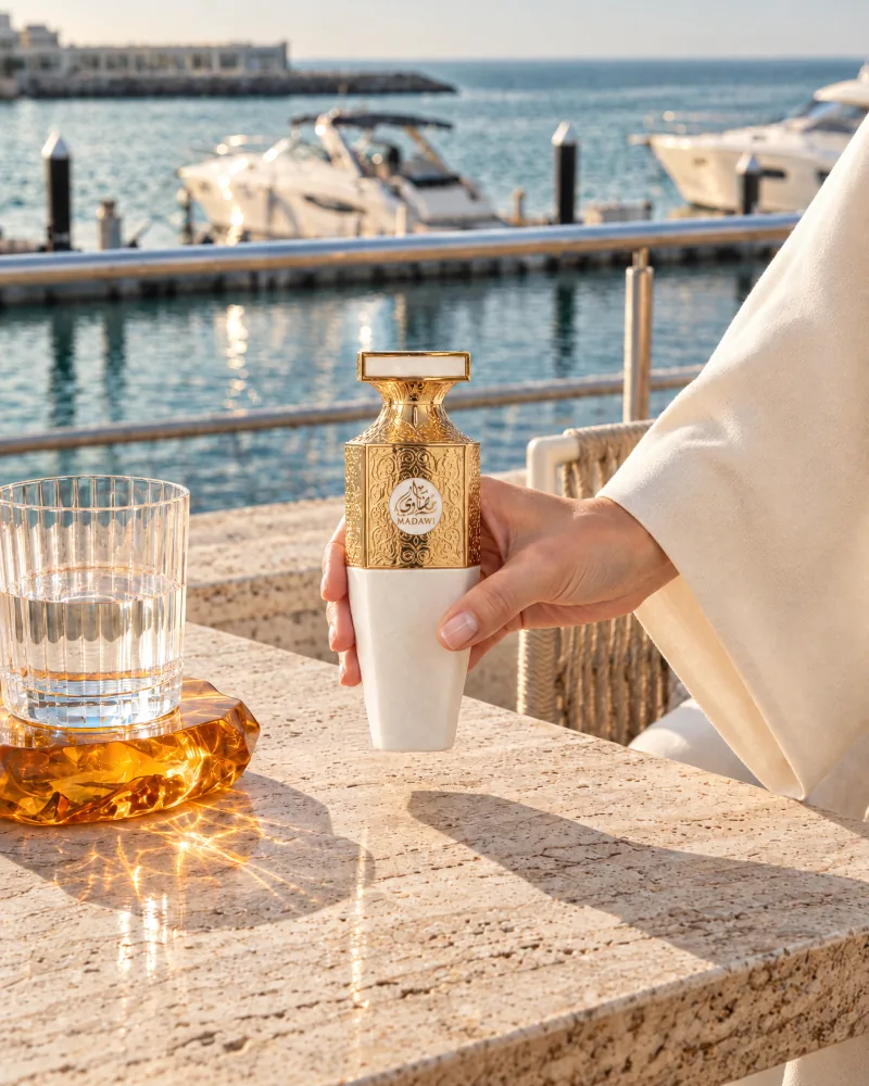 A hand holding Madawi White at a table overlooking the marina