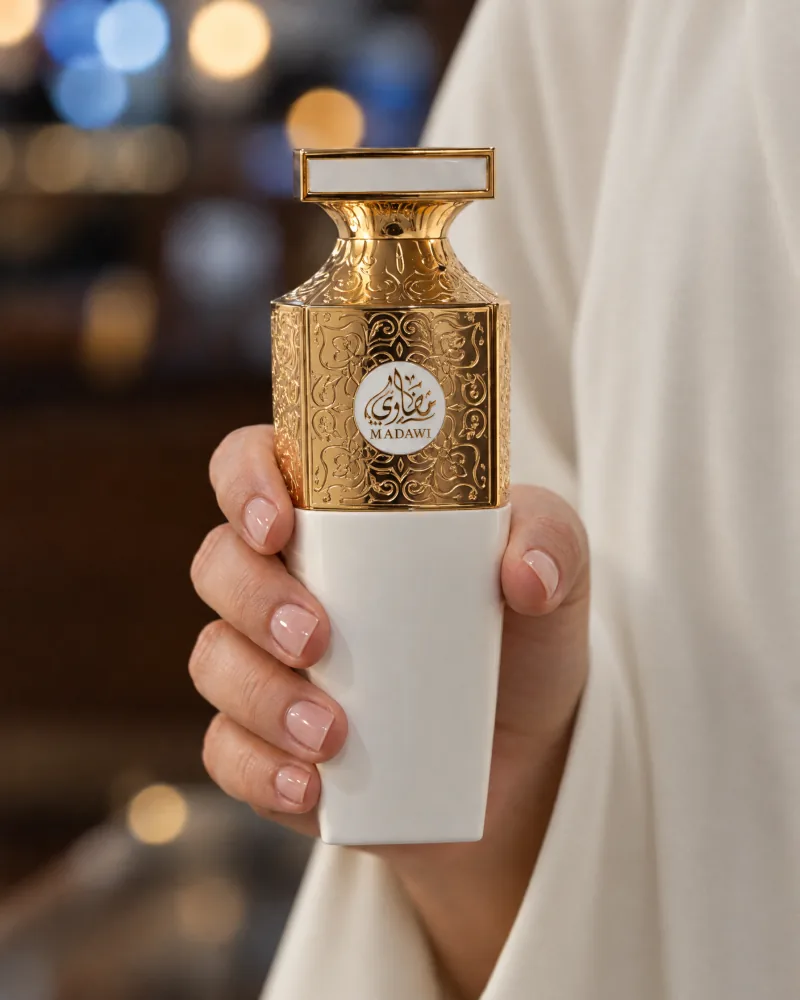 A hand holding Madawi White against evening lights